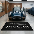 Jaguar garage floor mat, 5x7 ft (60x87"), iconic leaping cat emblem and JAGUAR wordmark in white on black background with dimensions shown.