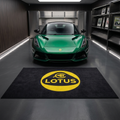 Lotus Cars garage floor mat, 5x7 ft (60x87"), bold yellow Lotus roundel and wordmark on black background with dimensions shown.
