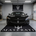 Large Maserati trident logo floor rug, 5x7 ft (approx. 150x220cm), with non-slip backing, displayed in a high-end luxury garage.