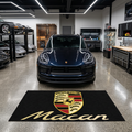 Porsche Macan garage floor mat, 5x7 ft (60x87"), full Porsche crest shield and gold Macan script on black background with dimensions shown.
